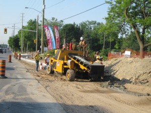 Loader and crew during a road reconstruction with traffic cones in place