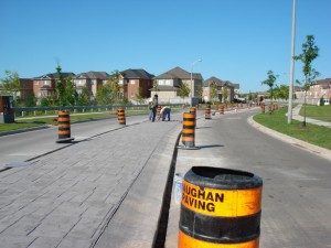 Finished stamped-concrete streetscape with a Vaughan Paving traffic barrel in the foreground