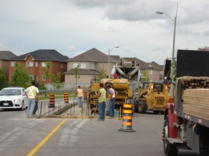 Crew setting out traffic barriers on a suburban street ahead of construction