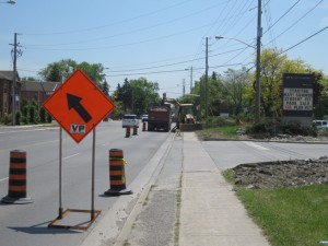 Vaughan Paving detour arrow board and traffic barrels set up on a roadside
